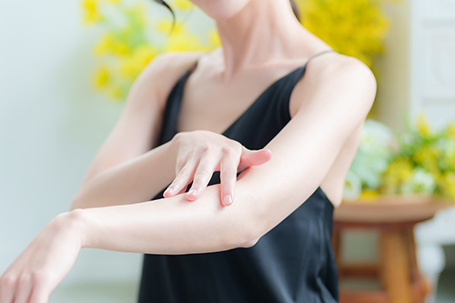 二の腕を気にする女性の写真